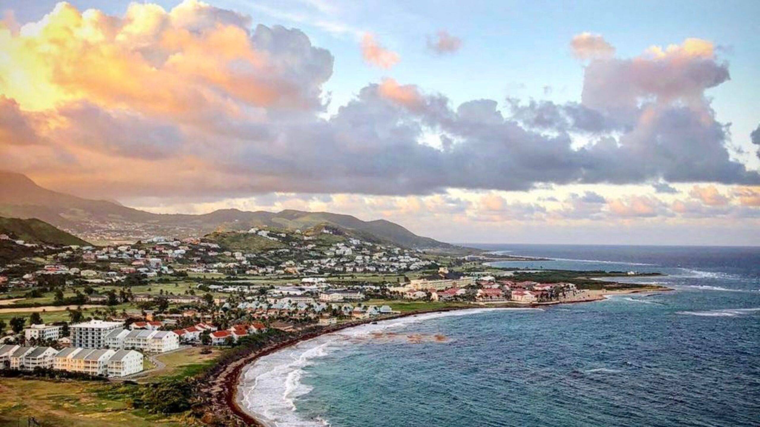 Coastal aerial sunset view of St Kitts peninsula with Frigate Bay showing residential developments and turquoise Caribbean waters for st kitts and nevis citizenship by investment 2025 programme