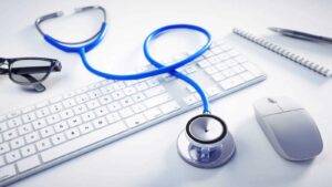 Medical stethoscope on professional desk with computer representing PLAB test UK visa requirements 2025 for international medical graduates