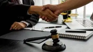 Immigration solicitor handshake with client representing UK immigration regularisation options 2025 legal assistance