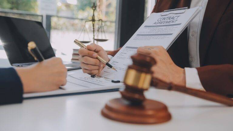 Immigration lawyer reviewing Section 94 certification documents with client, showing legal consultation for clearly unfounded asylum claims UK 2026