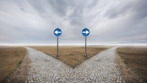 Directional arrow signs representing 5 year vs 10 year route UK 2025 immigration pathway choices