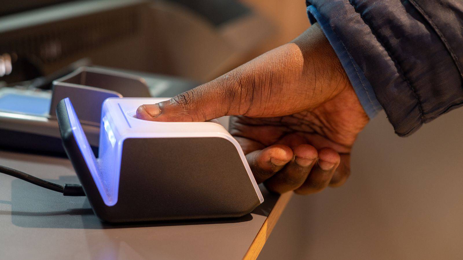 Hand using biometric fingerprint scanner for TOC application form 2025 biometric enrollment process