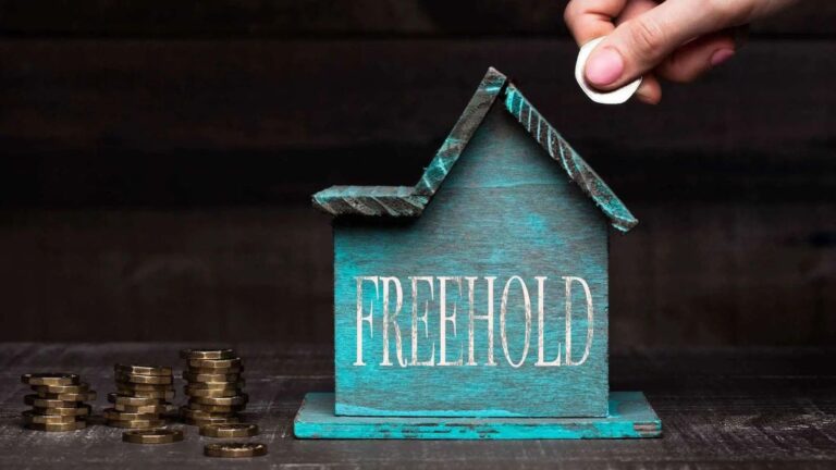 Turquoise House Model With Freehold Text And Coin Stacks Representing Buy Freehold Leasehold House Uk 2025 Purchase Costs And Enfranchisement Process