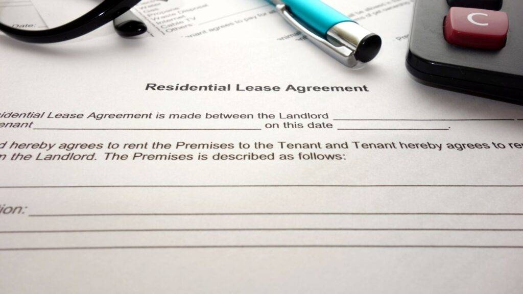 Residential lease agreement document with calculator representing long residential lease AST 2025 ground rent threshold calculations and assured shorthold tenancy classification risks