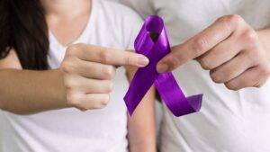 Hands holding purple awareness ribbon symbolizing violence against women and girls UK 2025 government strategy and legal framework