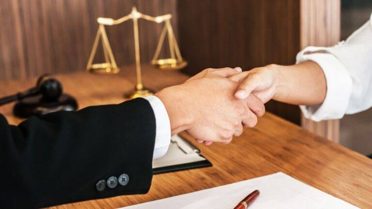 Professional handshake with scales of justice representing supportive legal consultation for employment rights illegal workers UK 2026