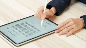 Professional signing digital property document on tablet with stylus - HM Land Registry Digital Transformation 2025 Guide showing QES qualified electronic signature requirements for paperless conveyancing