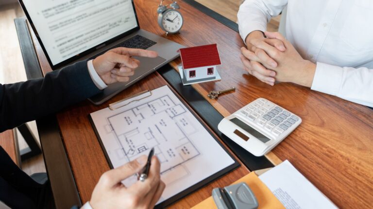 Professional property consultation with floor plans and house model representing statutory vs non statutory lease extension UK 2025 landlord strategic advice