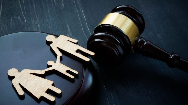Judicial gavel with broken separated wooden family figures representing breaching family court orders UK 2025 enforcement consequences and family breakdown