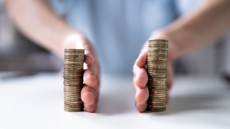 Person comparing two different-sized stacks of coins representing financial disclosure divorce UK 2025 Form E asset comparison and unequal financial positions