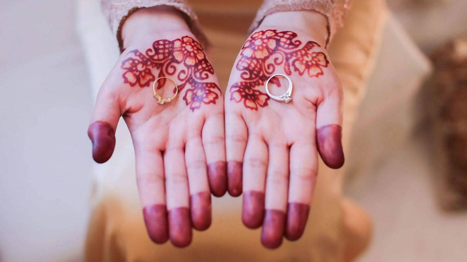 Wedding rings in henna-decorated hands representing Islamic marriage UK law combining traditional ceremonies with legal recognition requirements