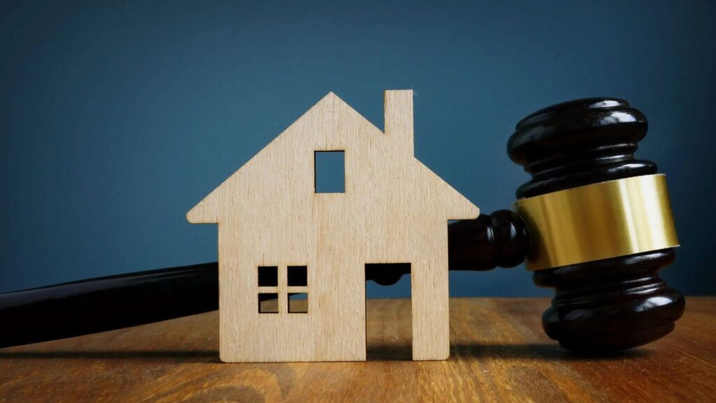 Wooden house model with judge's gavel representing matrimonial home rights notice legal protection and HR1 form Land Registry registration