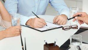 Unmarried couple signing cohabitation agreements UK 2025 legal document together at desk with professional consultation