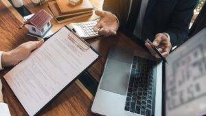 Professional Signing Purchase Contract For Freehold Property With House Model Calculator And Laptop Representing Purchasing Freehold Property Uk 2025