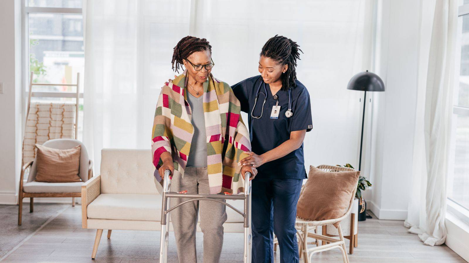 Healthcare professional assisting elderly person with mobility walker representing adult dependent relative visa UK 2025 care dependency requirements