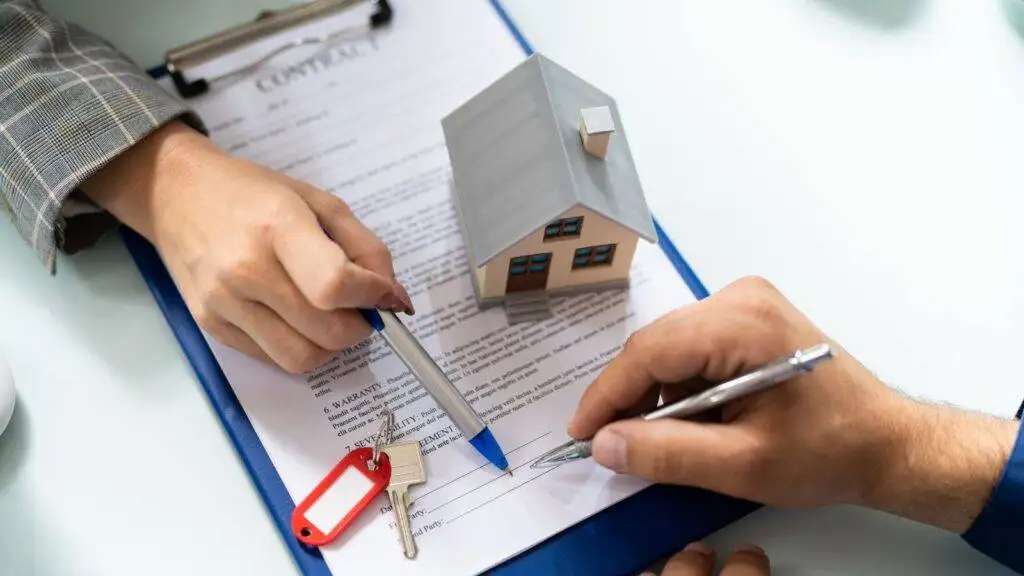 Professional signing property documents with house model and keys representing comprehensive purchasing leasehold property 2025 guide legal process