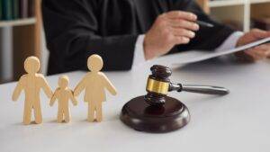 Wooden Family Figures With Judge'S Gavel Representing What Is Cafcass Uk 2025 Role In Court