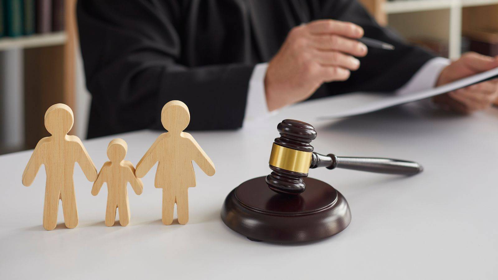 Wooden family figures with judge's gavel representing what is CAFCASS UK 2025 role in court