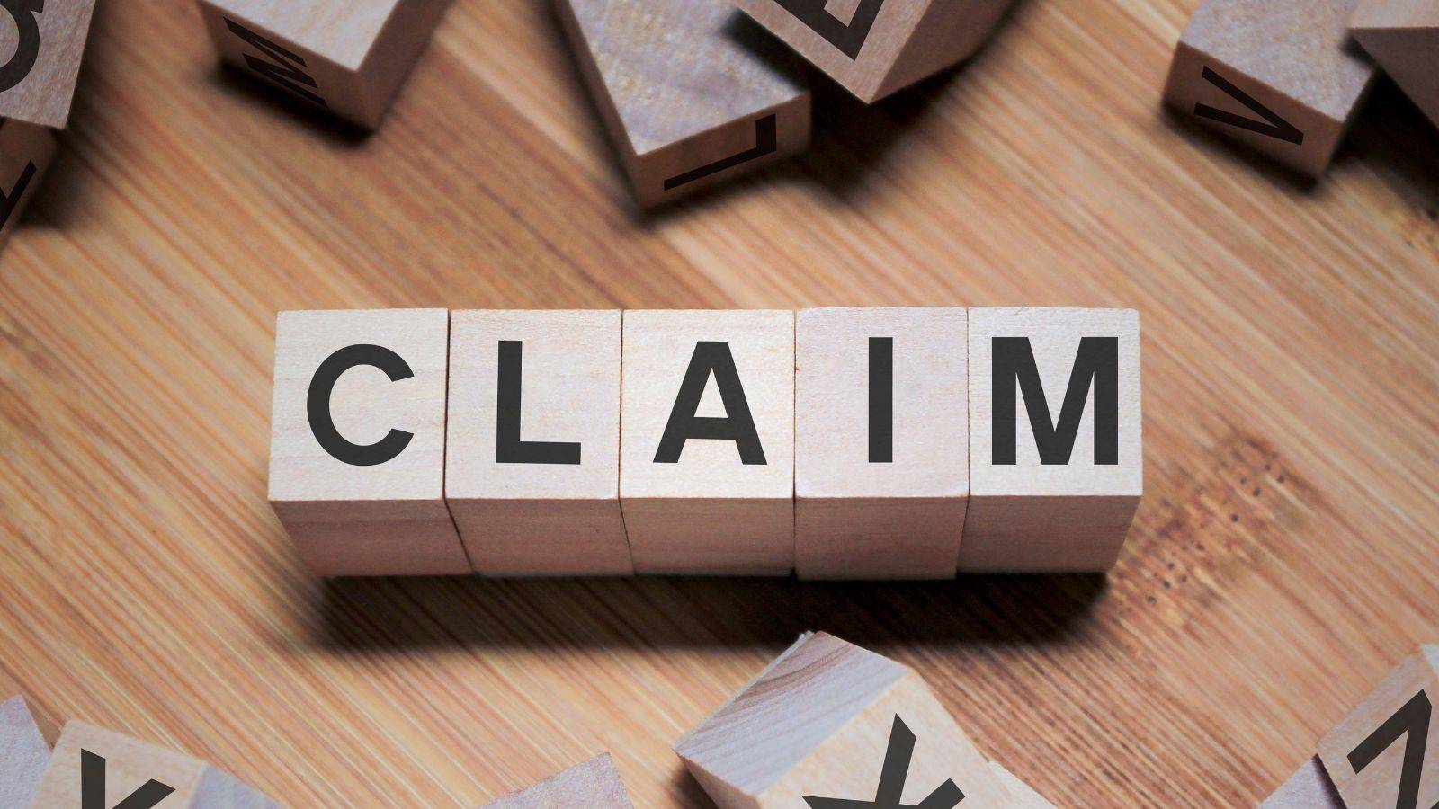 Wooden letter blocks spelling CLAIM representing the fresh claims process for UK visa fresh claim 2025 applications and legal procedures