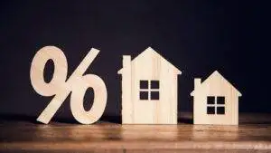 Wooden percentage symbol and house outline representing remortgage conveyancing UK 2025 interest rates and legal process