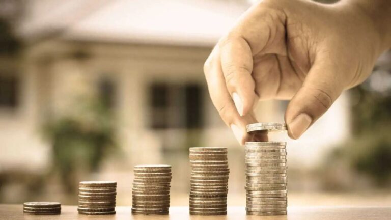 Hand protecting growing coin stacks representing adequate maintenance spouse visa 2025 financial requirements and income thresholds