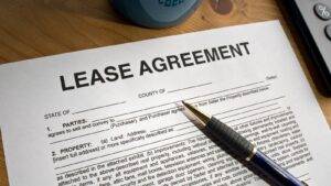 Lease Agreement Document With Calculator And Pen Representing Grant Of New Lease Uk 2025 Premium Calculations And Landlord Legal Requirements