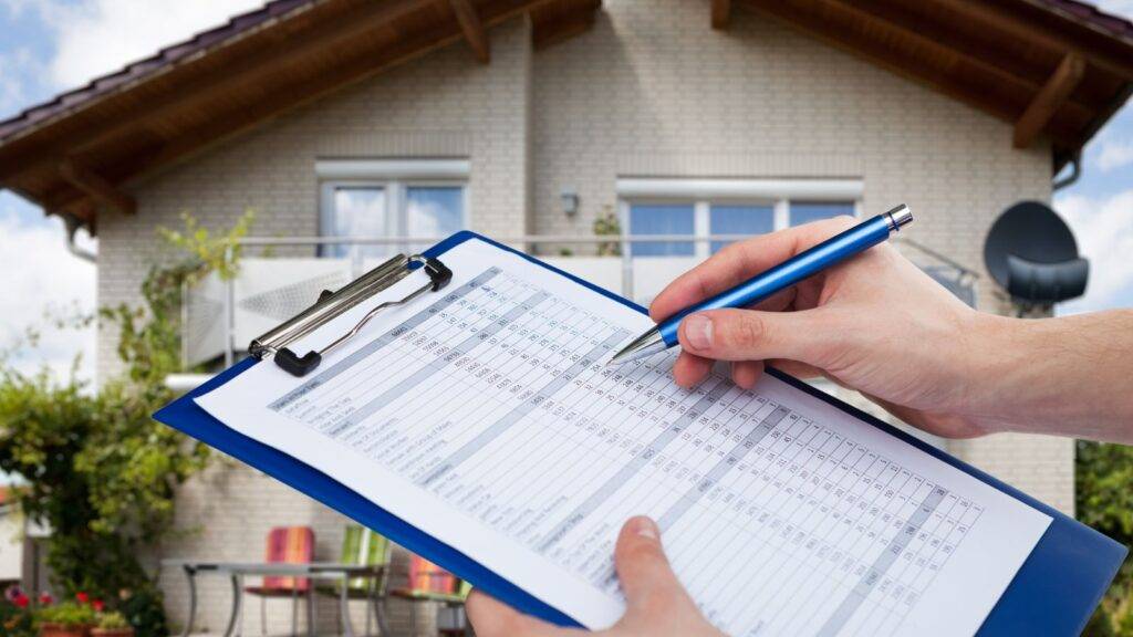 Professional property surveyor conducting on-site inspection with clipboard documentation at residential property representing divorce valuation UK 2025 property assessment process