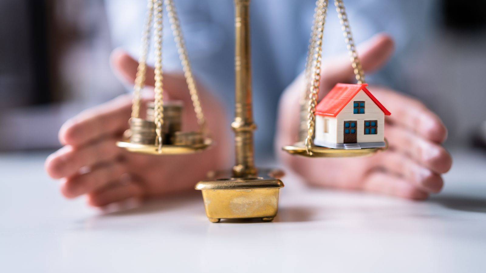 Scales of justice with protected house model representing ring-fencing assets divorce UK 2025 legal protection strategies