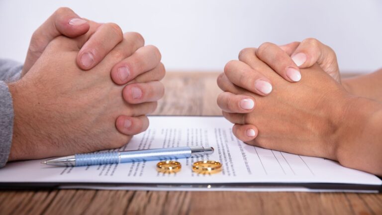 Two hands protecting legal documents with wedding rings representing sharing principle family law UK 2025 financial proceedings