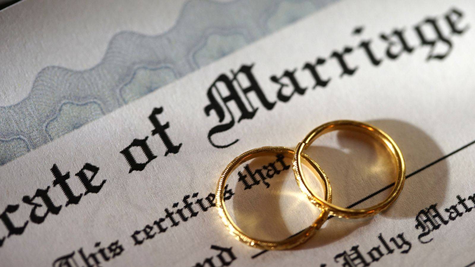 UK marriage age legal requirements with wedding rings on marriage certificate representing 2025 marriage laws