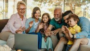 Multi-generational family gathered with laptop representing strategies to avoid family conflict after death UK 2025 through estate planning and open communication