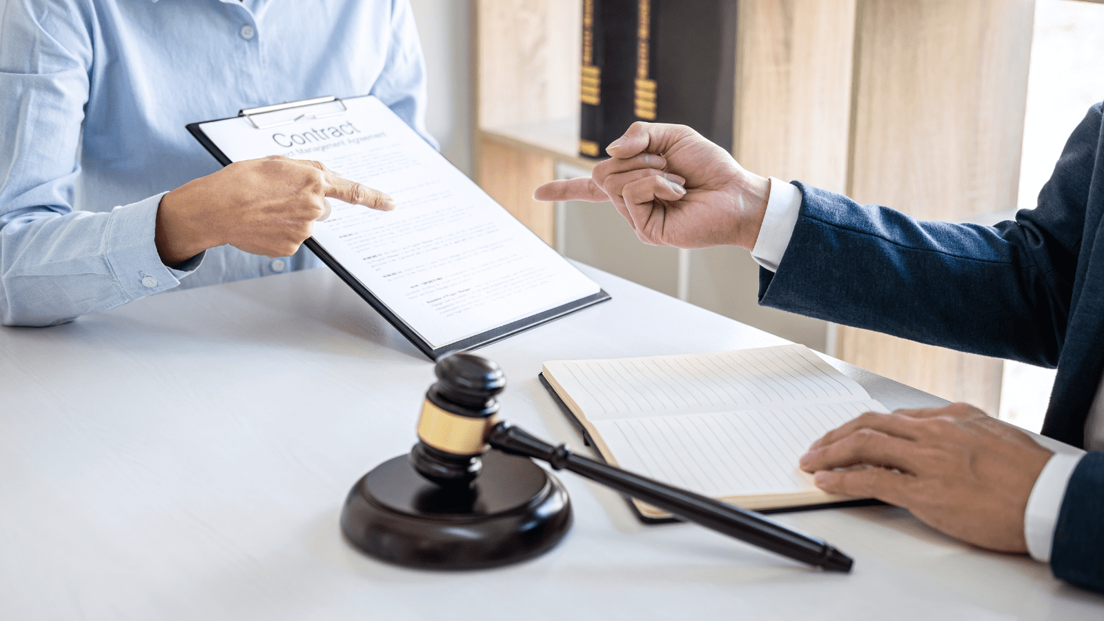Client and solicitor reviewing contract with gavel on desk at Connaught Law office
