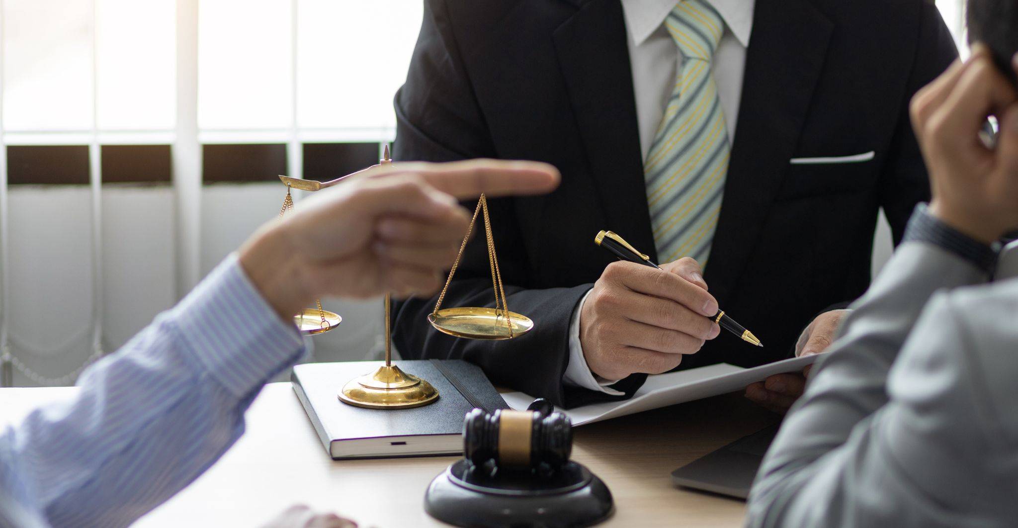 Business professionals with scales of justice and legal gavel representing contractual disputes solicitors UK 2025 commercial negotiation services