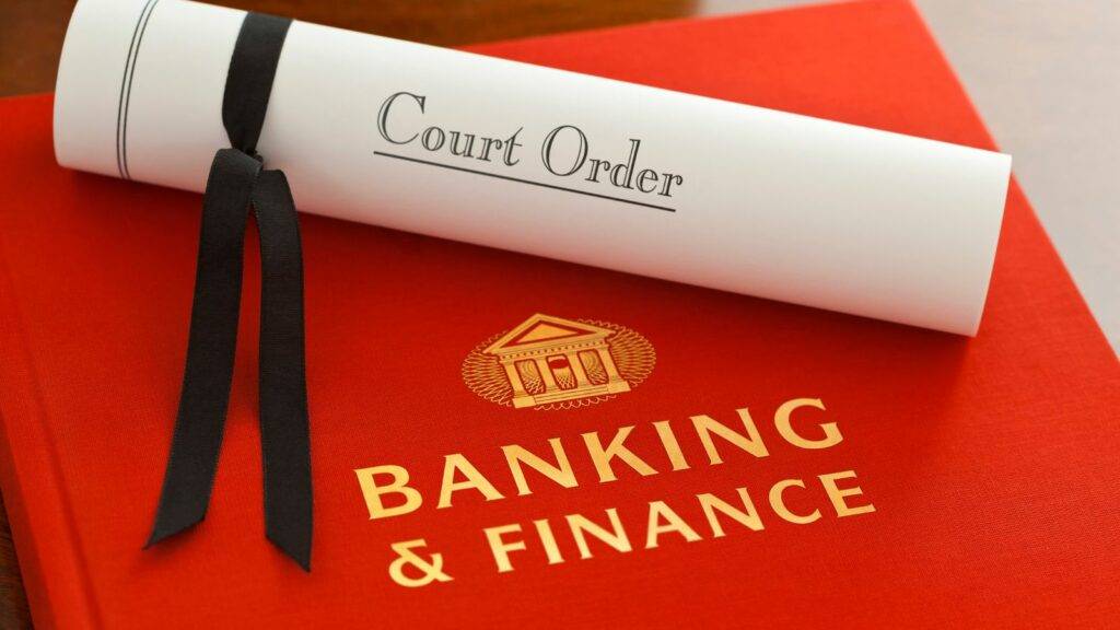 Court order document on red Banking and Finance law book representing financial services disputes.