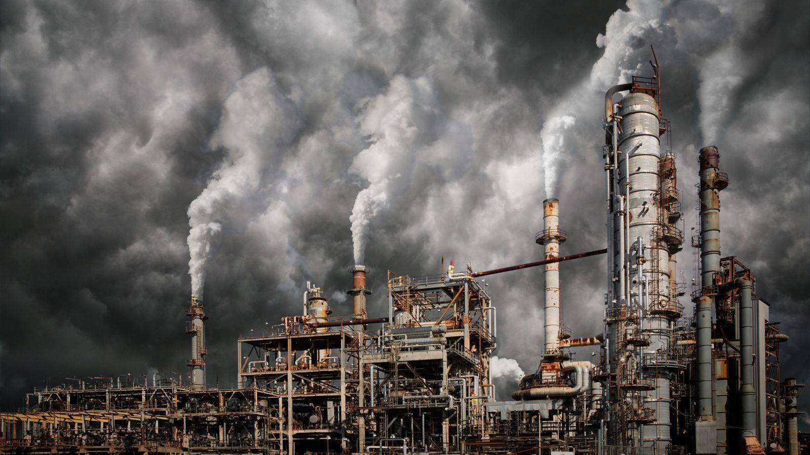 Industrial factory with heavy smoke illustrating industrial disease risk - Industrial Disease Claims