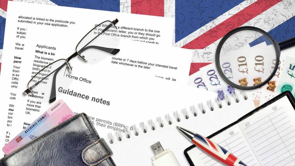 UK settlement and citizenship documents, British residence permit, guidance notes, and currency under magnifying glass.