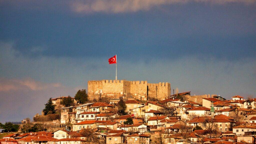 Turkish castle fortress with flag representing Ankara Agreement ECAA immigration routes for Turkish nationals