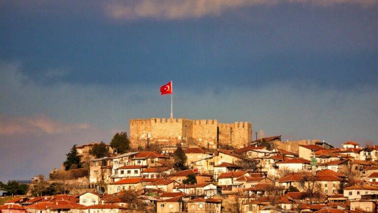 Turkish castle fortress with flag representing Ankara Agreement ECAA immigration routes for Turkish nationals