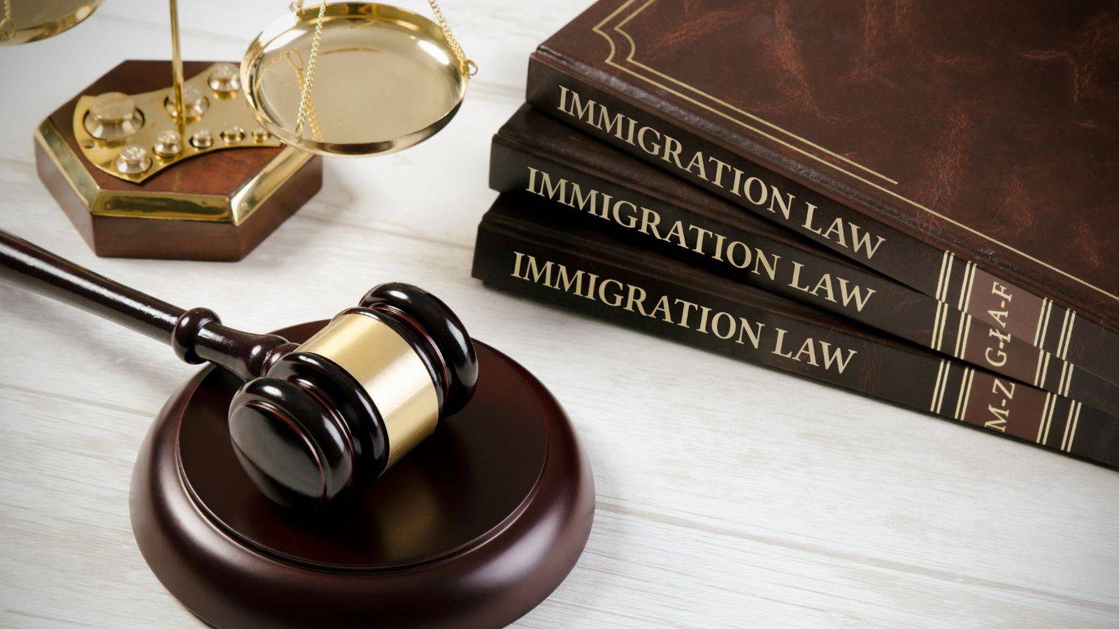 Professional immigration law books with wooden gavel and golden scales of justice representing UK immigration solicitors 2025 legal expertise