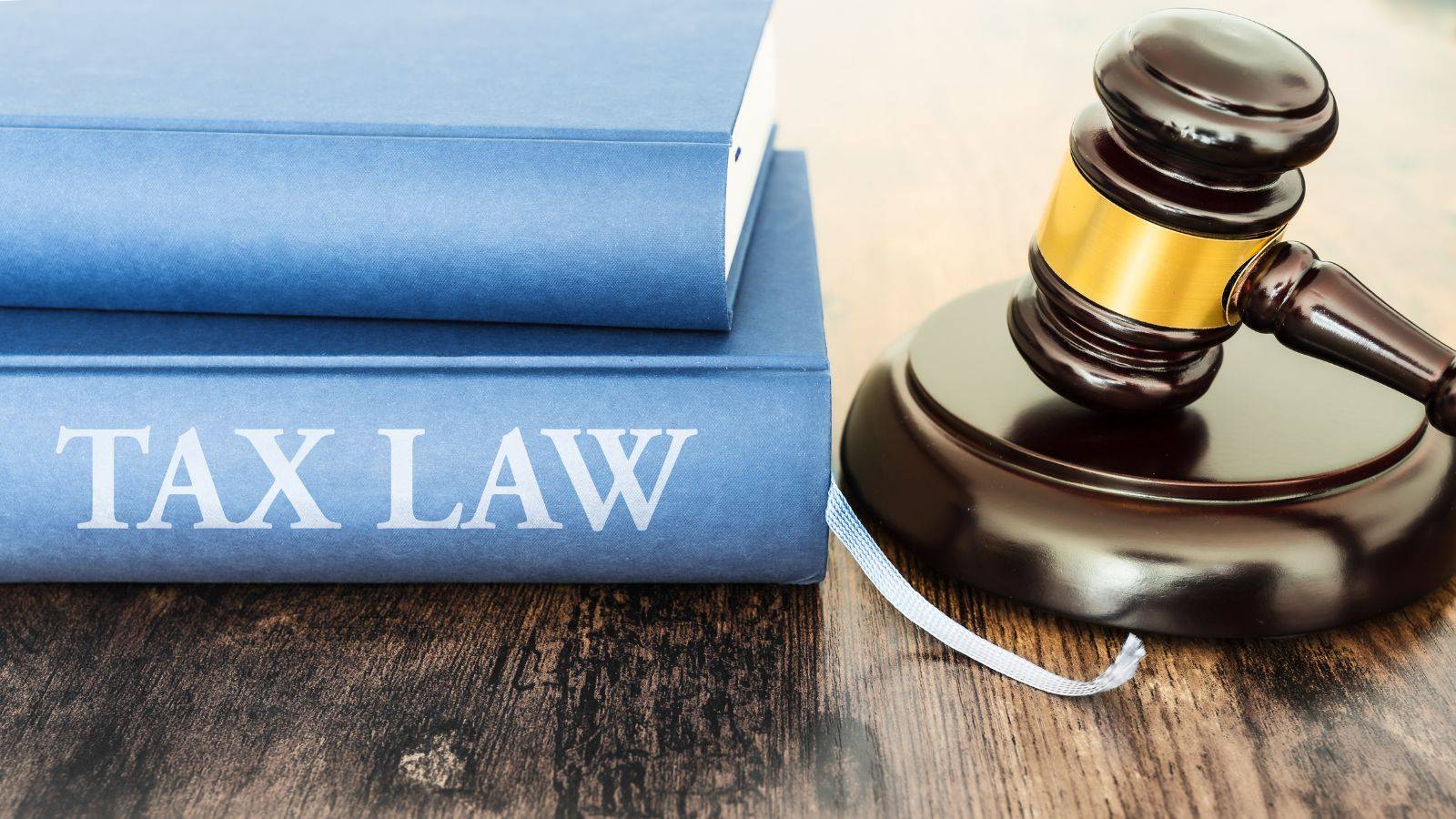 Professional legal library with blue tax law books and wooden gavel representing expert tax law solicitors UK 2025 services