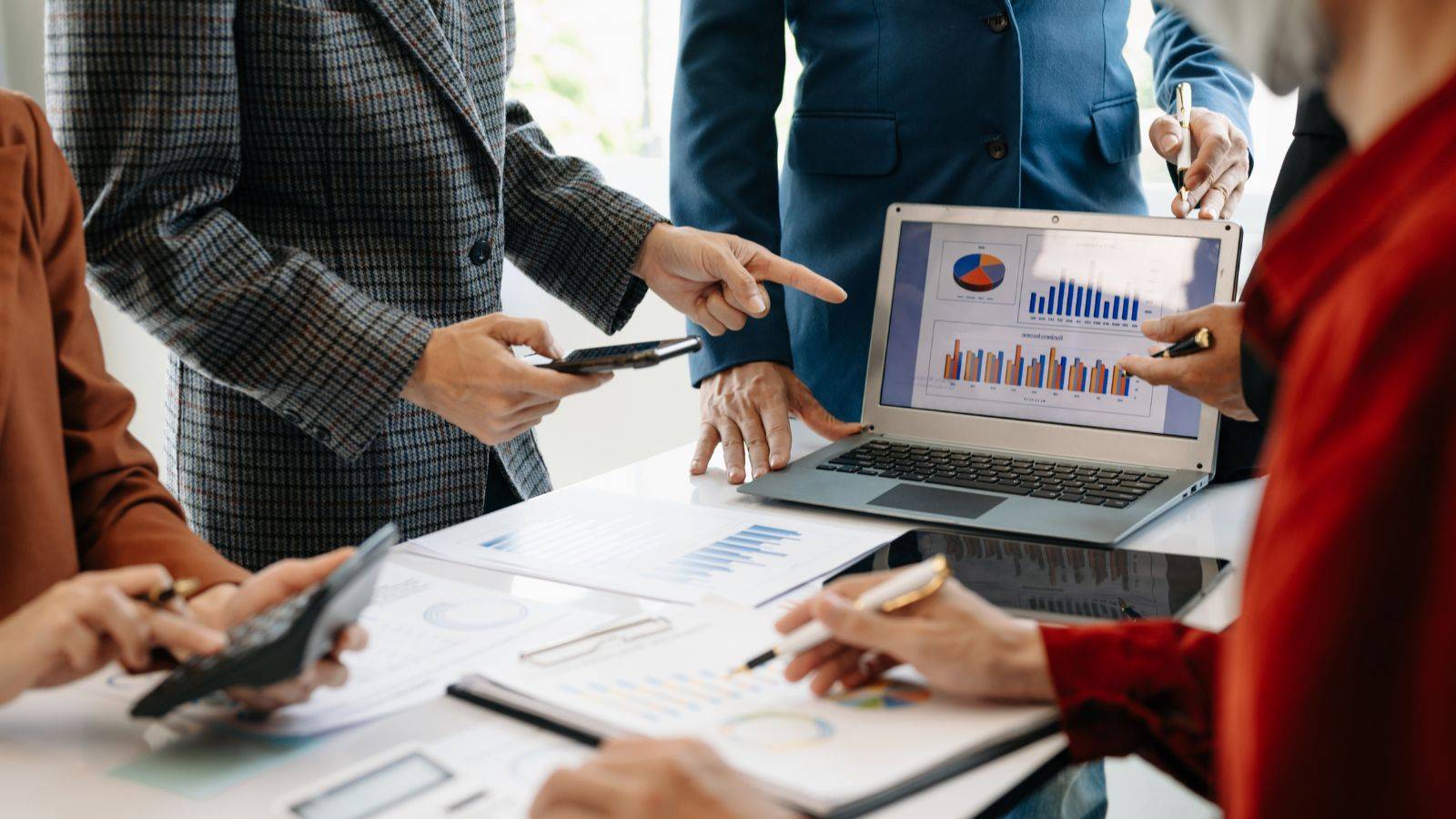 Professionals discussing tax and corporate law strategies with financial charts and graphs