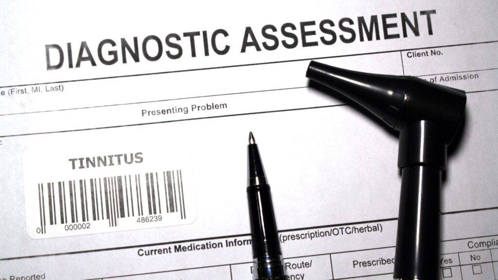 Tinnitus diagnostic assessment form with medical equipment representing tinnitus compensation calculator UK 2025