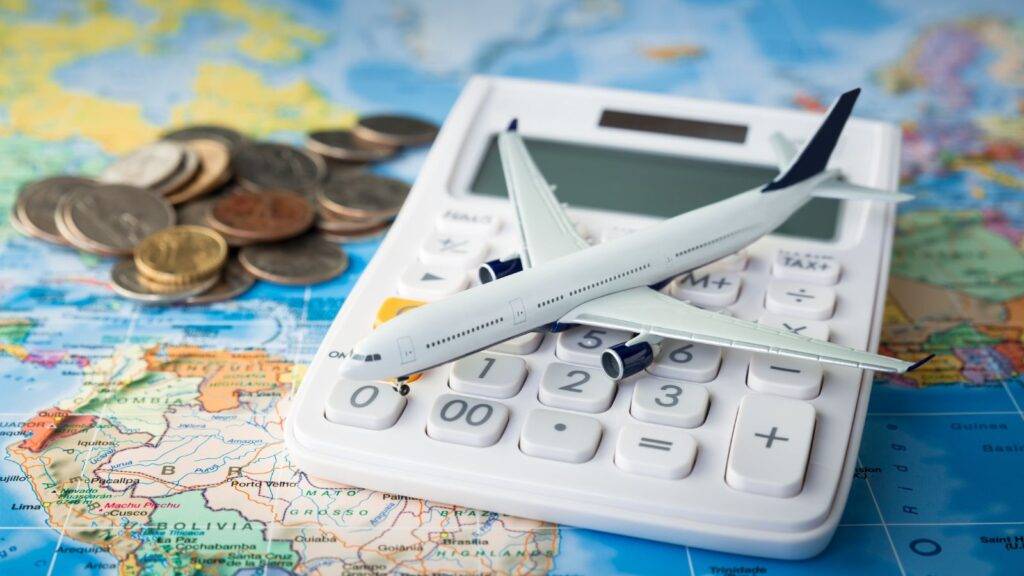 White airplane model on world map with calculator and coins representing accident abroad compensation calculator 2025 for international injury settlement estimates