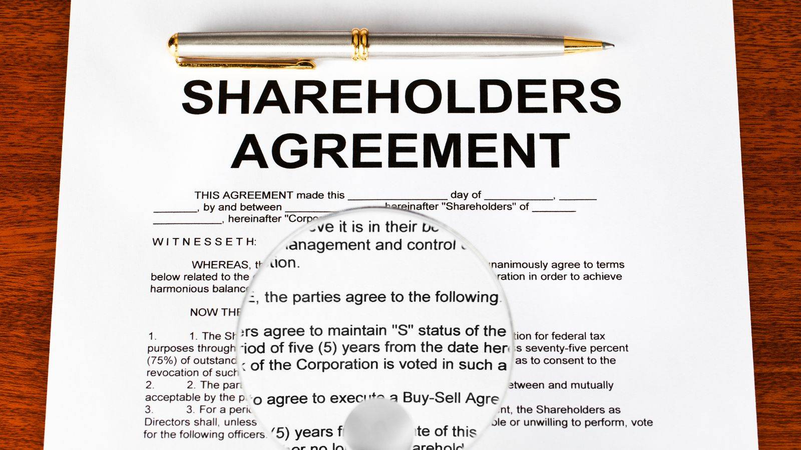 Detailed shareholders agreement document with gold pen showing legal clauses for UK share classes disputes 2025 litigation prevention and corporate governance
