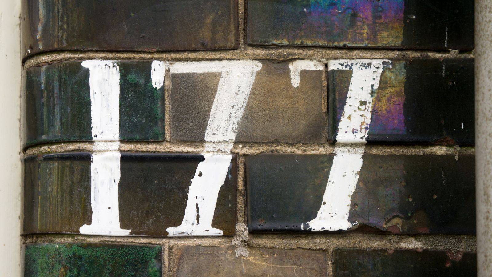 Weathered brick wall showing number 177 representing UK housing history timeline spanning 177 years of British property law evolution and housing development from 1848 to 2025