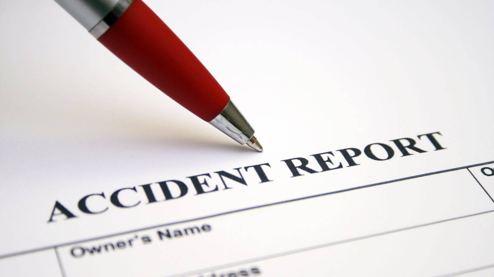 Accident report form with red pen showing car accident compensation UK 2025 legal documentation and claims procedure for road traffic accident injury compensation