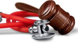 Legal gavel resting on red stethoscope representing misdiagnosis compensation claims UK 2025 civil medical negligence legal authority and clinical error claims procedure