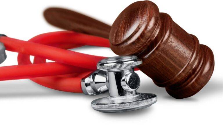 Legal gavel resting on red stethoscope representing misdiagnosis compensation claims UK 2026 civil medical negligence legal authority and clinical error claims procedure