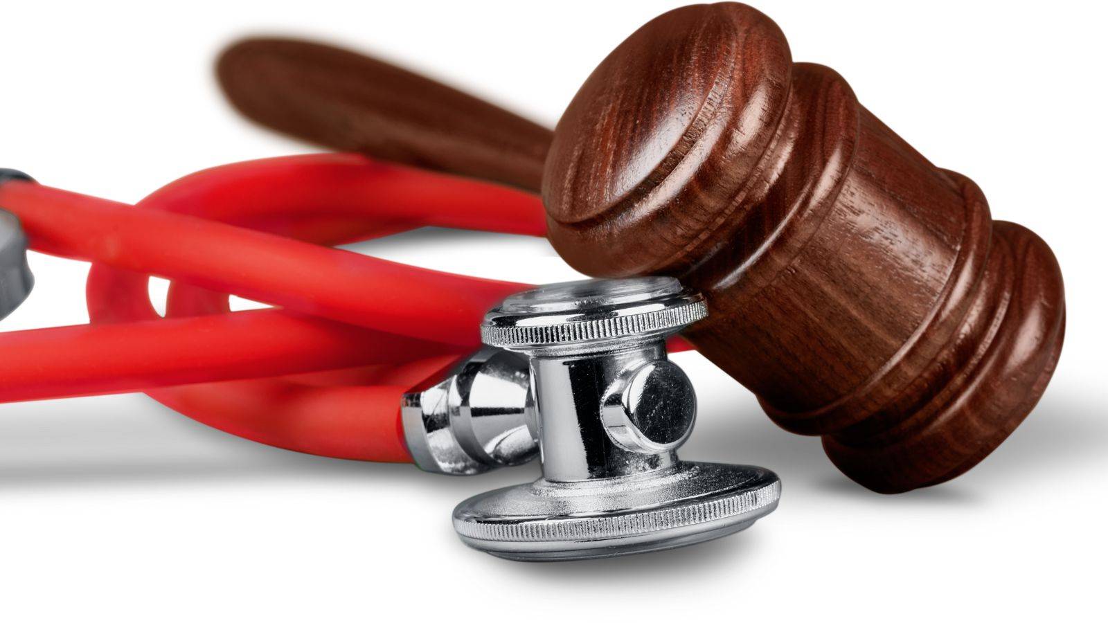 Legal gavel resting on red stethoscope representing misdiagnosis compensation claims UK 2025 civil medical negligence legal authority and clinical error claims procedure