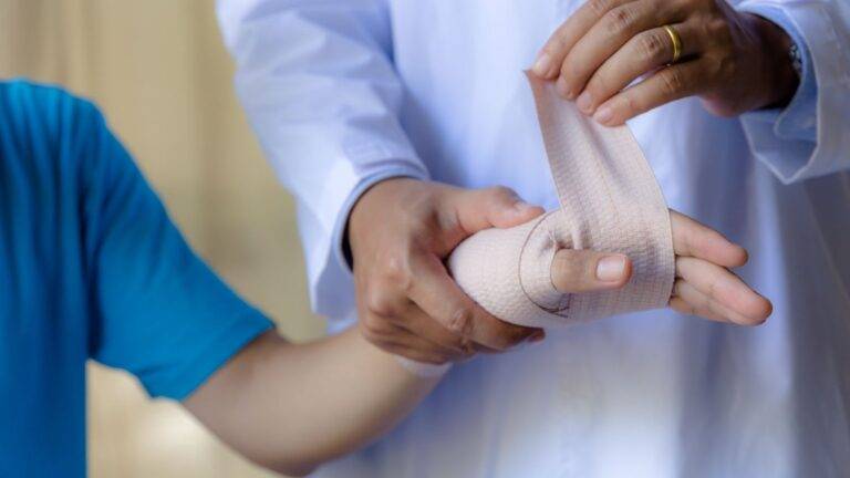 Healthcare professional providing medical care and support to patient with bandaged hand following finger injury treatment for hand finger injury compensation UK 2026 legal claim documentation and medical evidence